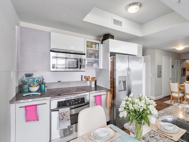 kitchen featuring white cabinetry, appliances with stainless steel finishes, and dark wood-type flooring