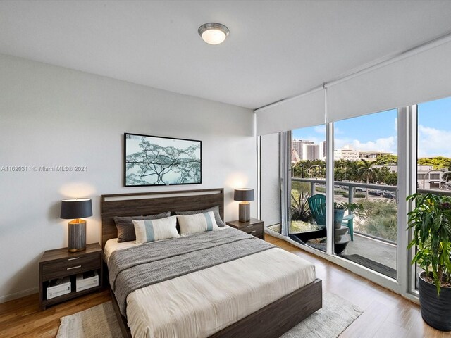 bedroom with multiple windows, access to outside, and light hardwood / wood-style flooring