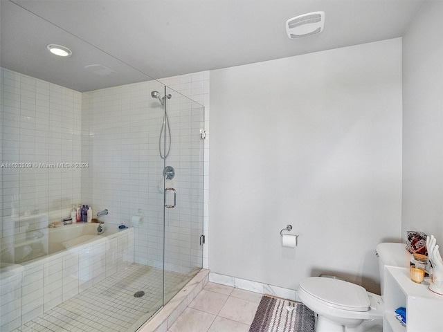 bathroom with tile patterned floors, toilet, and separate shower and tub