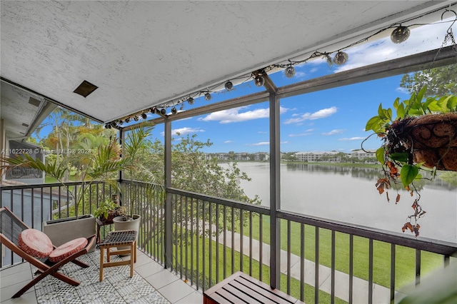 sunroom featuring a water view