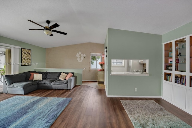 living room with lofted ceiling, ceiling fan, and dark wood-type flooring