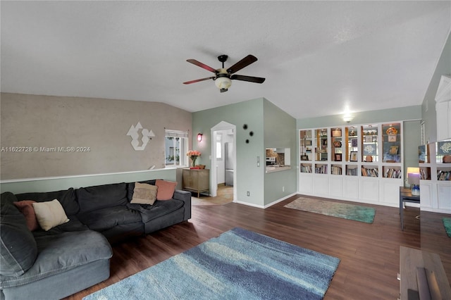 living room featuring ceiling fan, vaulted ceiling, and dark wood-type flooring