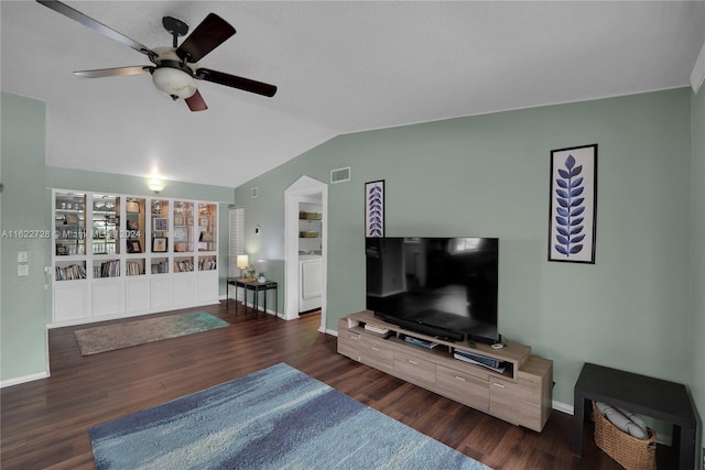 living room with washer / clothes dryer, dark hardwood / wood-style floors, ceiling fan, and vaulted ceiling