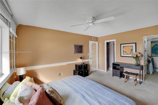 carpeted bedroom featuring a textured ceiling and ceiling fan