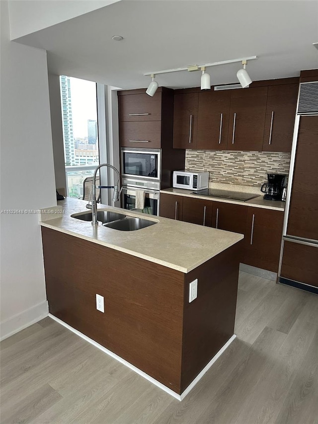 kitchen with rail lighting, tasteful backsplash, black appliances, and dark brown cabinets