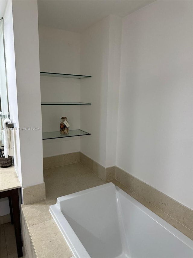 bathroom featuring tile patterned flooring and a bath