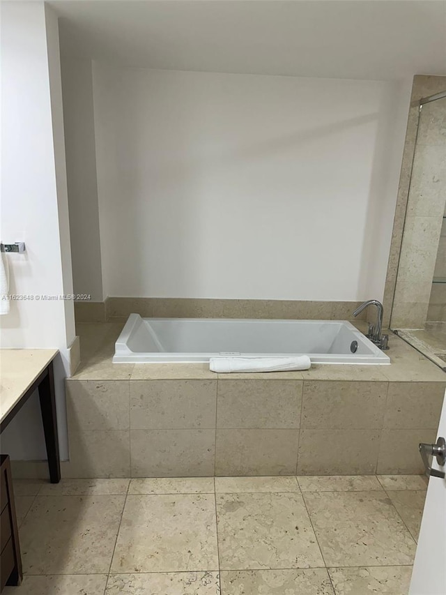 bathroom with vanity, tiled bath, and tile patterned flooring