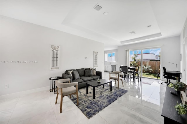 tiled living room with a tray ceiling