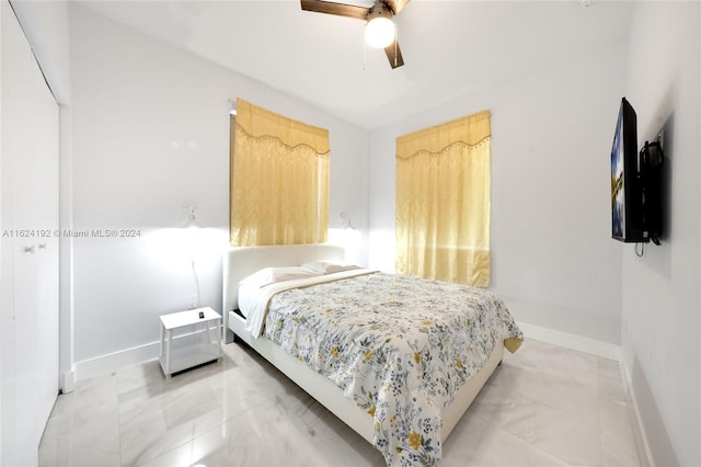 tiled bedroom featuring ceiling fan