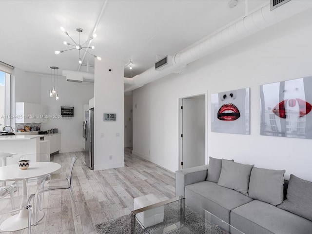 living room featuring a notable chandelier and light hardwood / wood-style flooring