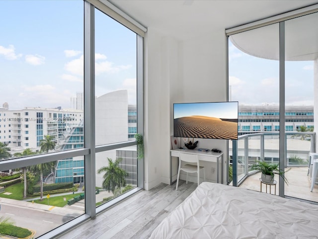 bedroom featuring light hardwood / wood-style floors, floor to ceiling windows, and multiple windows