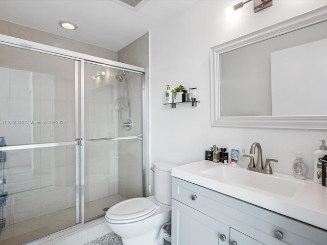 bathroom with toilet, a shower with door, and vanity