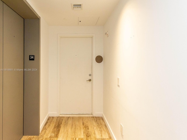 entryway with elevator and light hardwood / wood-style flooring