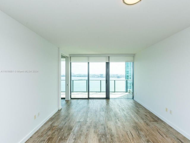 unfurnished room featuring light hardwood / wood-style flooring and expansive windows
