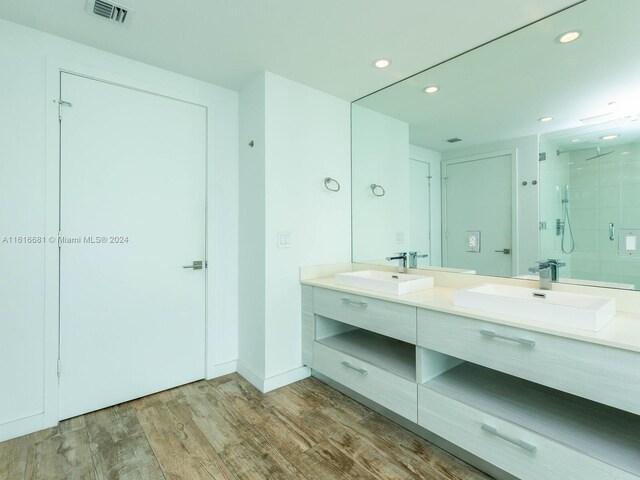 bathroom featuring wood-type flooring, vanity, and walk in shower