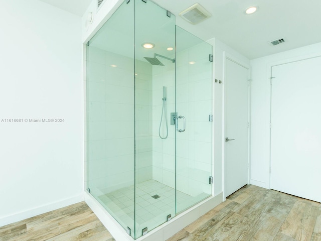 bathroom featuring hardwood / wood-style floors and a shower with door