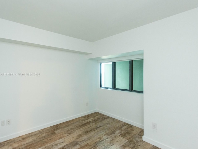 unfurnished room with hardwood / wood-style floors