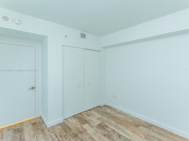 unfurnished bedroom featuring hardwood / wood-style flooring and a closet