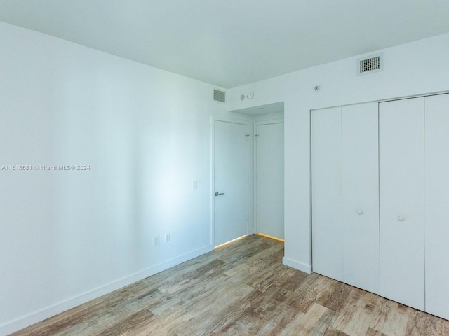 unfurnished bedroom with light hardwood / wood-style floors and a closet