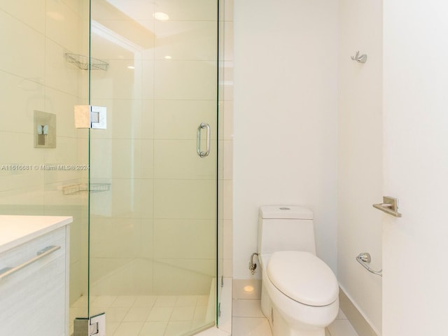 bathroom featuring vanity, tile patterned flooring, a shower with door, and toilet