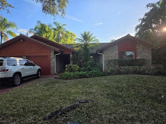 single story home featuring a garage and a front lawn