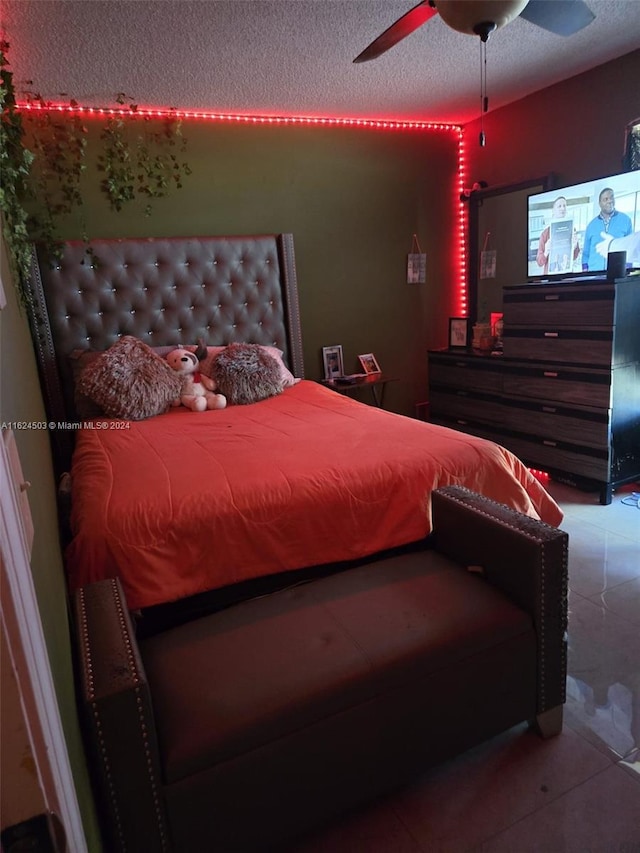 tiled bedroom with a textured ceiling and ceiling fan