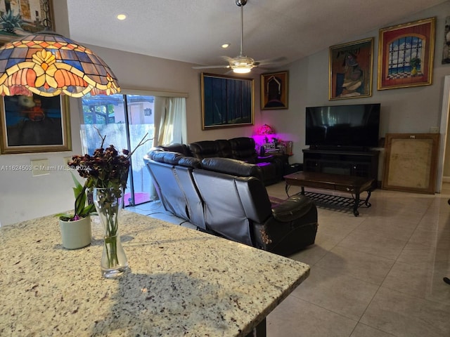 tiled living room with ceiling fan and a textured ceiling