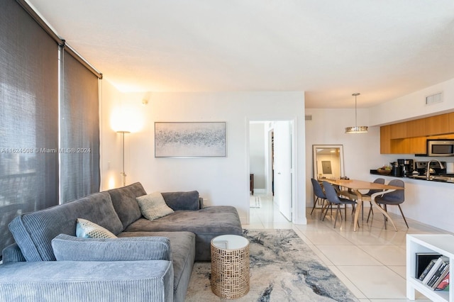 living room featuring sink and light tile patterned flooring