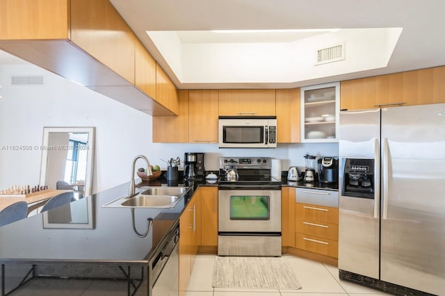 kitchen with light tile patterned floors, stainless steel appliances, and sink