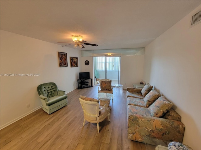 living room with light hardwood / wood-style flooring, expansive windows, and ceiling fan