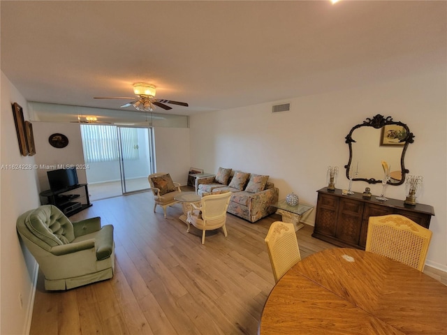 living room featuring ceiling fan and light hardwood / wood-style flooring