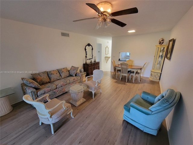 living room with ceiling fan and hardwood / wood-style floors