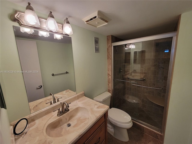 bathroom featuring toilet, tile patterned flooring, walk in shower, and vanity