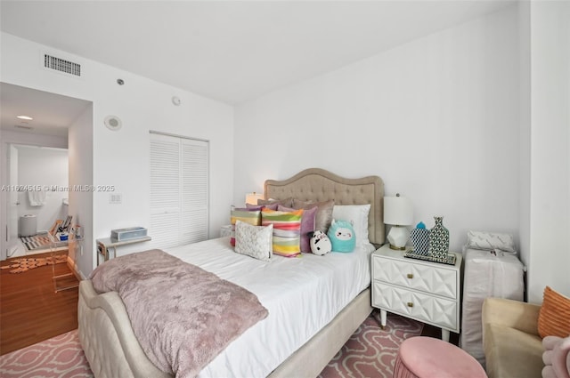 bedroom with wood-type flooring and a closet