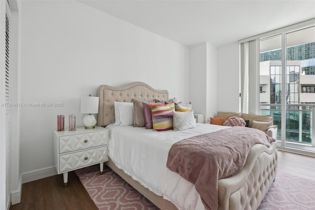 bedroom with expansive windows, access to outside, and hardwood / wood-style flooring