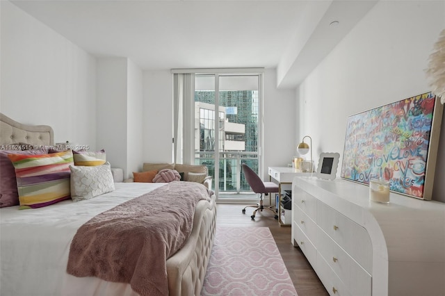 bedroom with access to exterior, expansive windows, and dark hardwood / wood-style floors