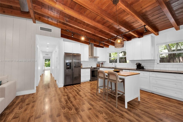 kitchen with stainless steel appliances, a healthy amount of sunlight, rail lighting, and wooden ceiling