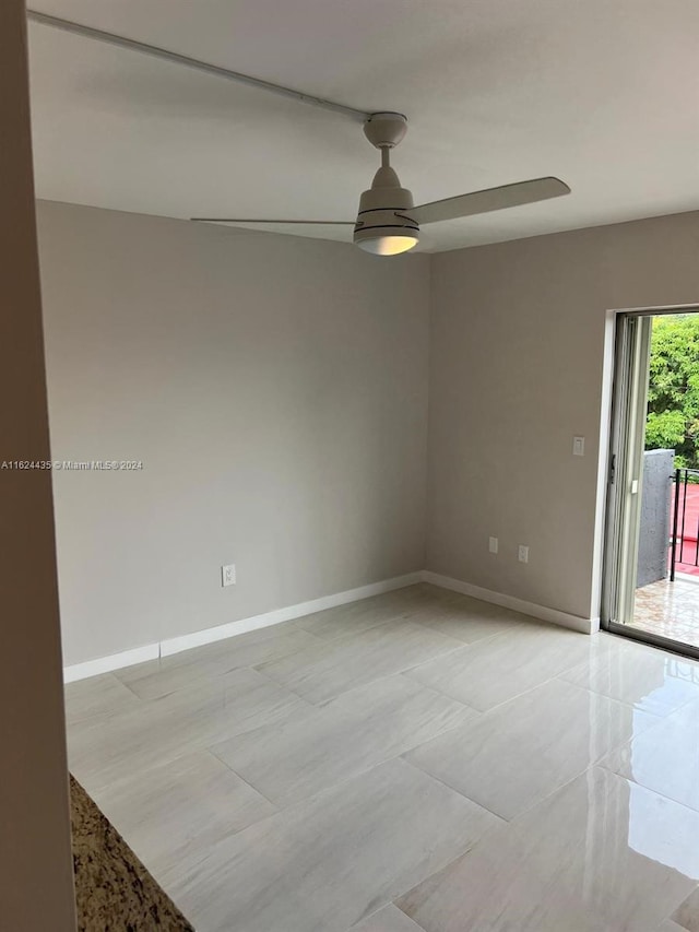 tiled spare room featuring ceiling fan