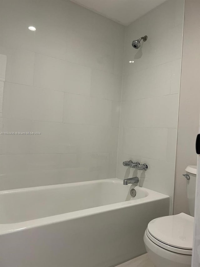 bathroom featuring tiled shower / bath and toilet