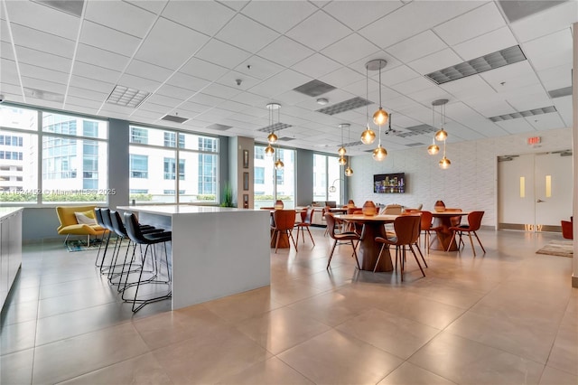 dining room with a wealth of natural light and a drop ceiling