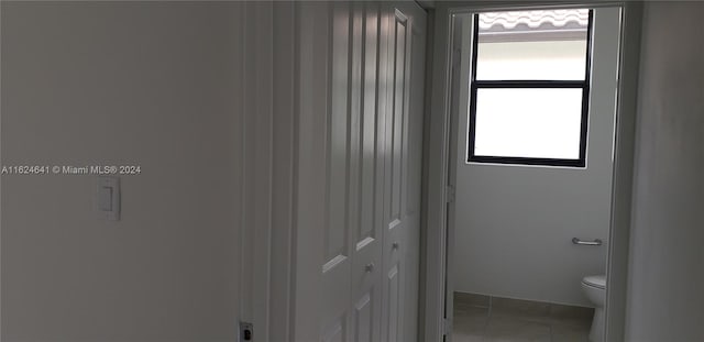 bathroom with tile patterned flooring, toilet, and a wealth of natural light