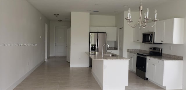 kitchen with stainless steel appliances, white cabinets, an island with sink, sink, and light tile patterned floors