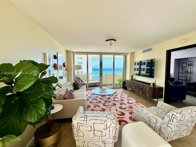 living room featuring expansive windows, a water view, and carpet floors