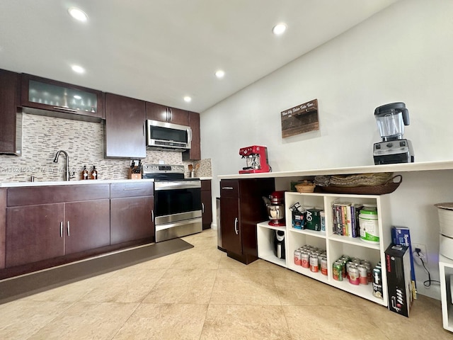 kitchen with light tile patterned flooring, sink, appliances with stainless steel finishes, tasteful backsplash, and dark brown cabinets