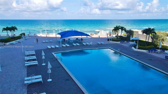 view of pool featuring a patio and a water view