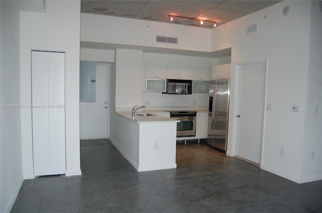 kitchen with sink, track lighting, white cabinets, and stainless steel appliances