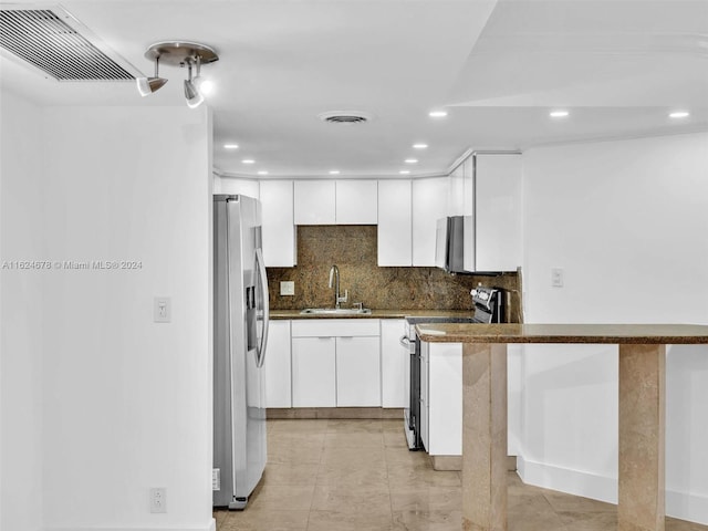 kitchen featuring sink, stainless steel appliances, kitchen peninsula, and white cabinets