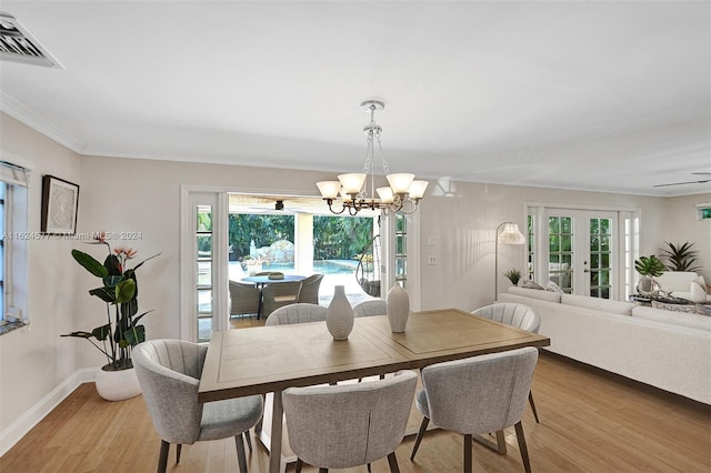 dining area with crown molding, french doors, hardwood / wood-style floors, and a chandelier