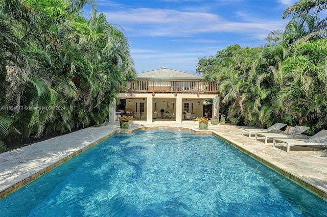 outdoor pool with french doors and a patio