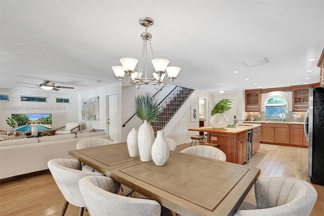 dining area with recessed lighting, light wood-style flooring, stairway, and ceiling fan with notable chandelier